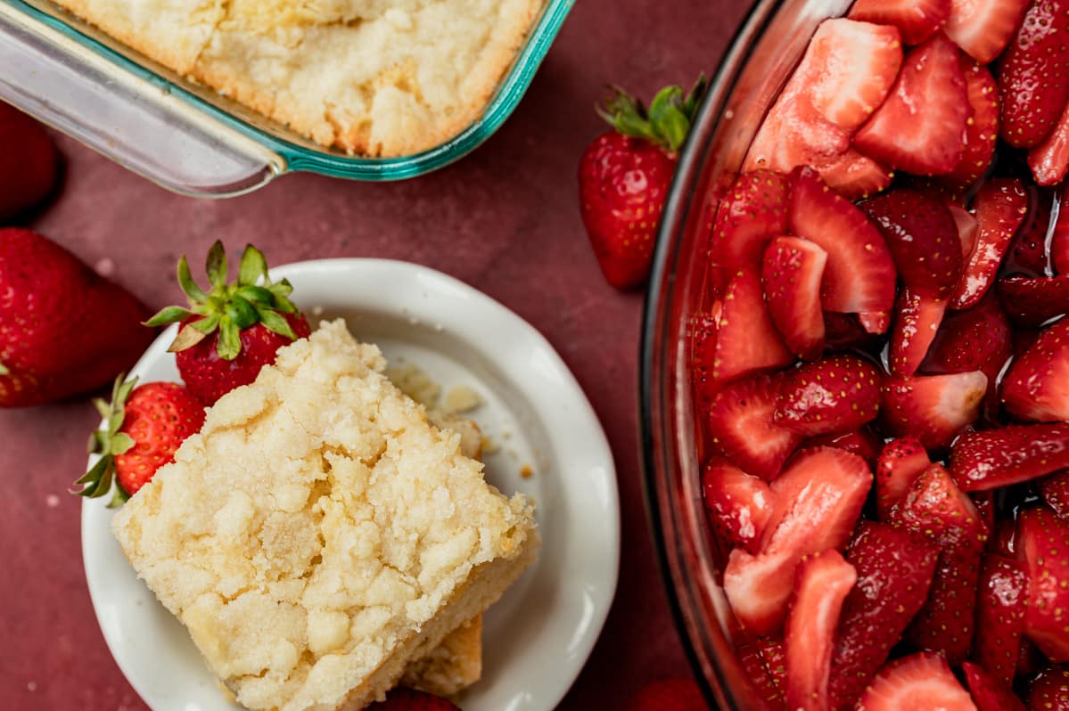 strawberries in a bowl with shortcake on the side.