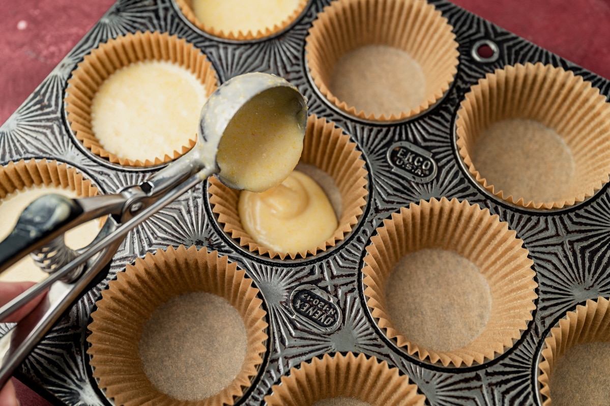 scooping batter into a muffin pan