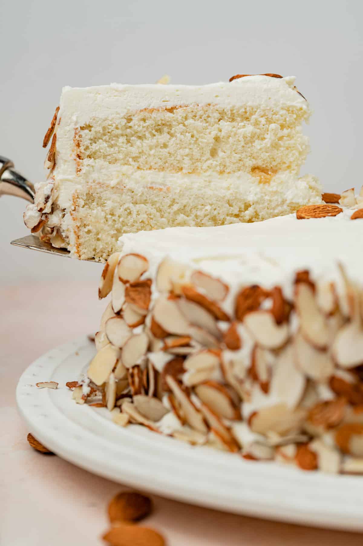 a slice of white cake with almonds on a spatula