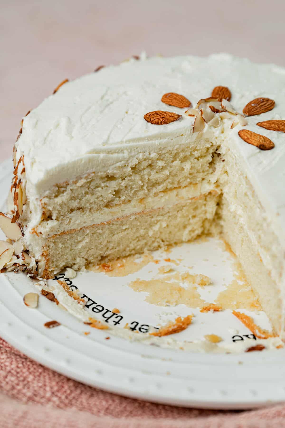 overhead view of a white almond cake on a plate