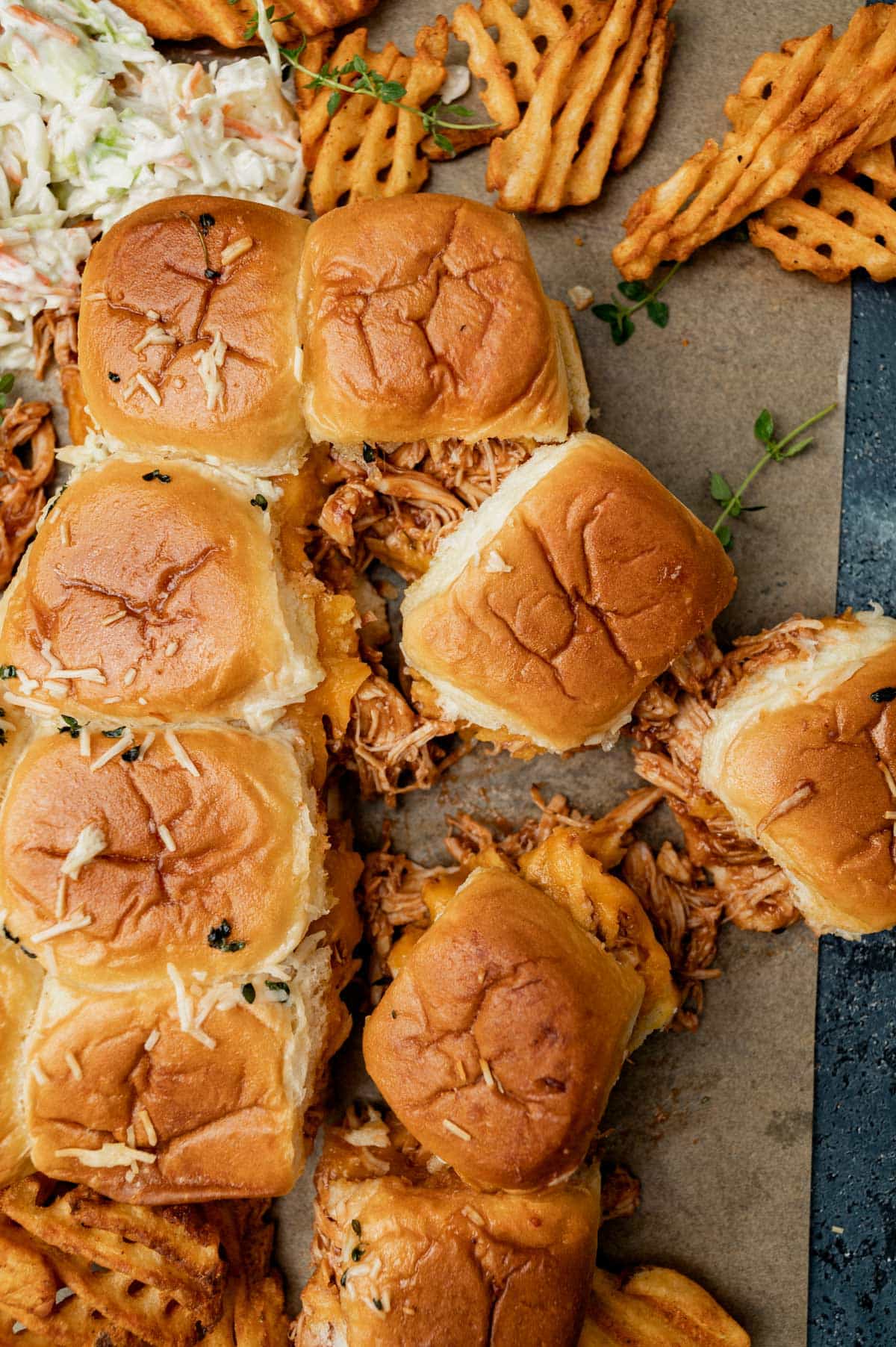 overhead view of bbq chicken sliders, waffle fries and coleslaw