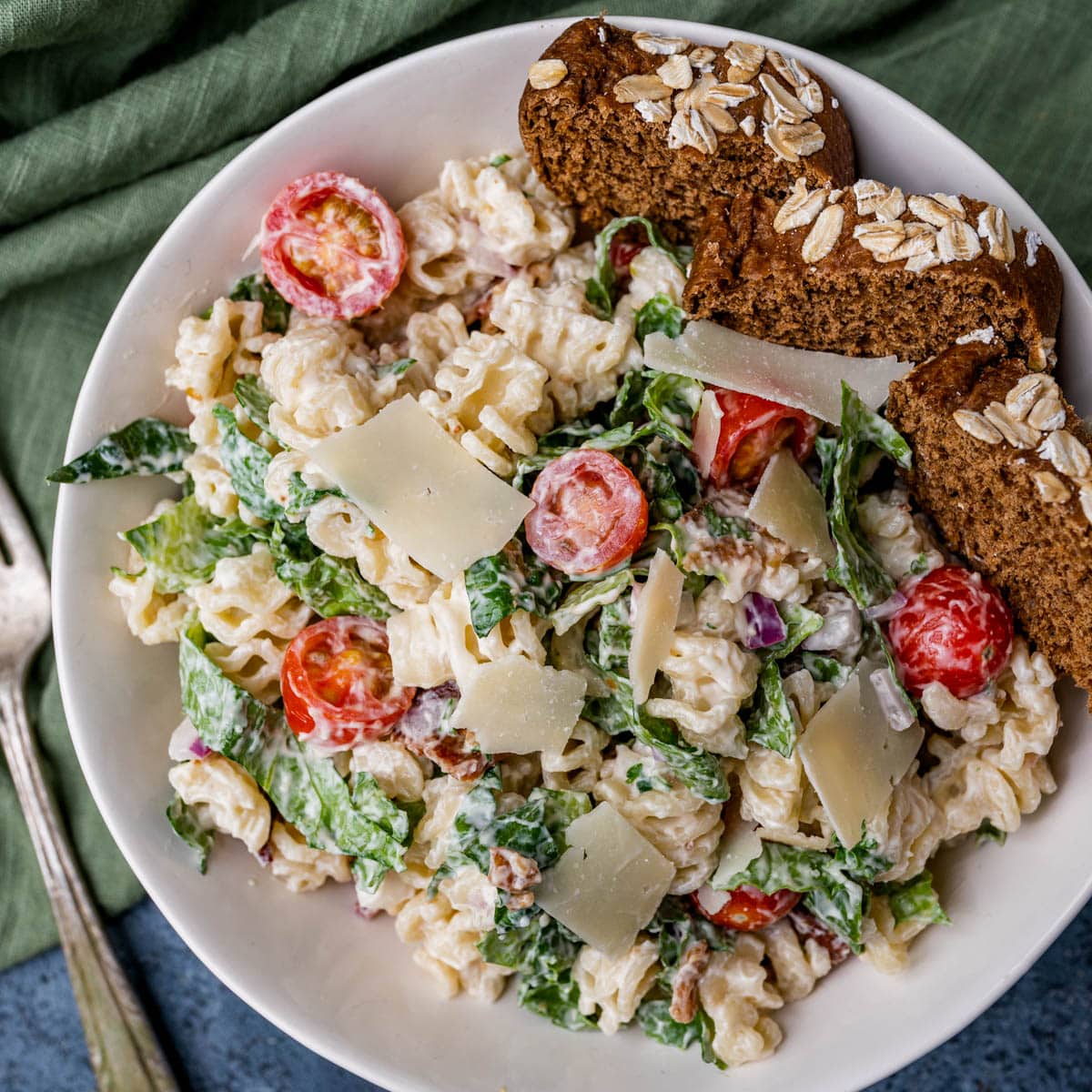 overhead view of a plate of blt pasta salad with bread