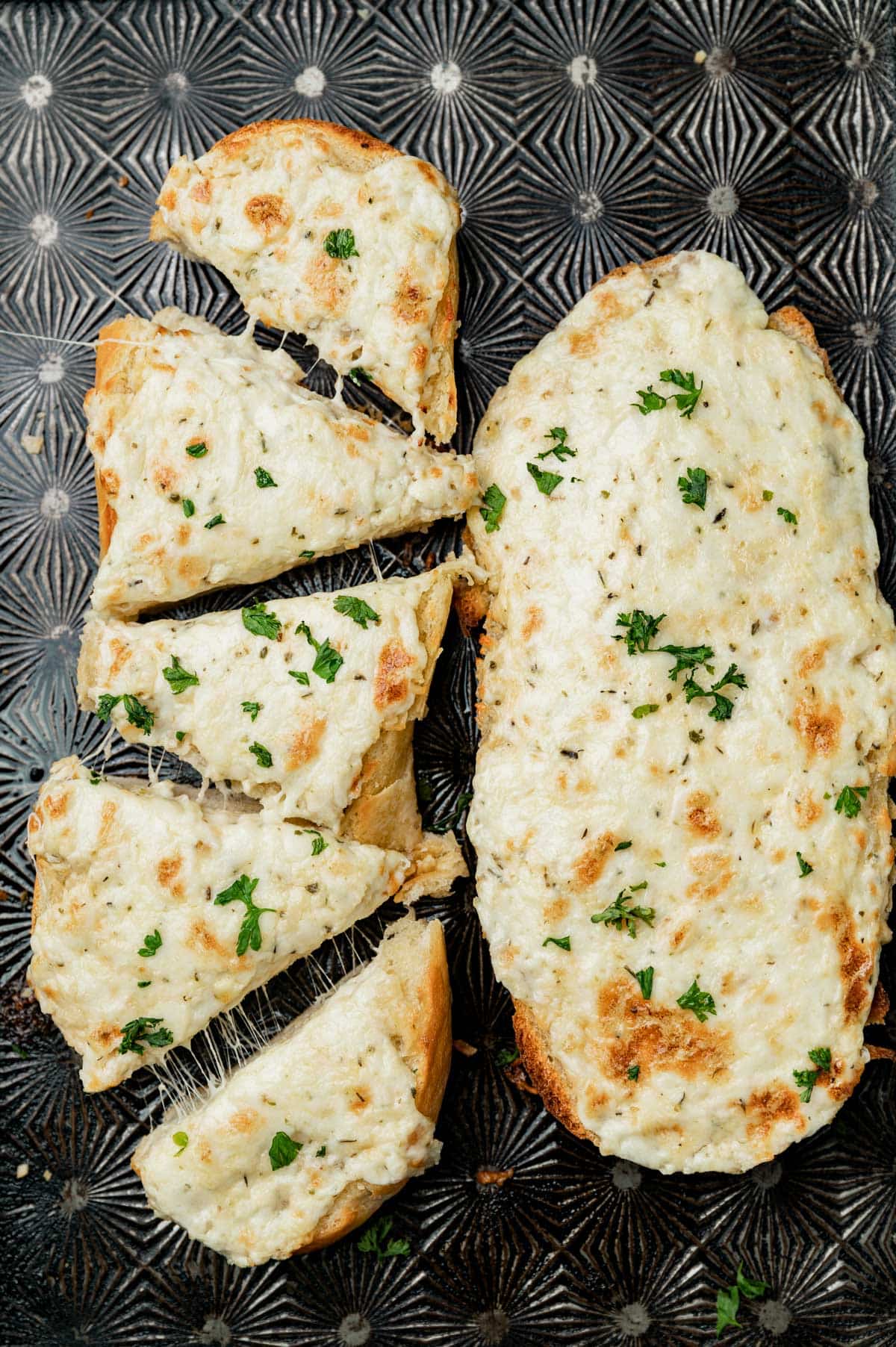 overhead view of two loaves of garlic bread, one sliced