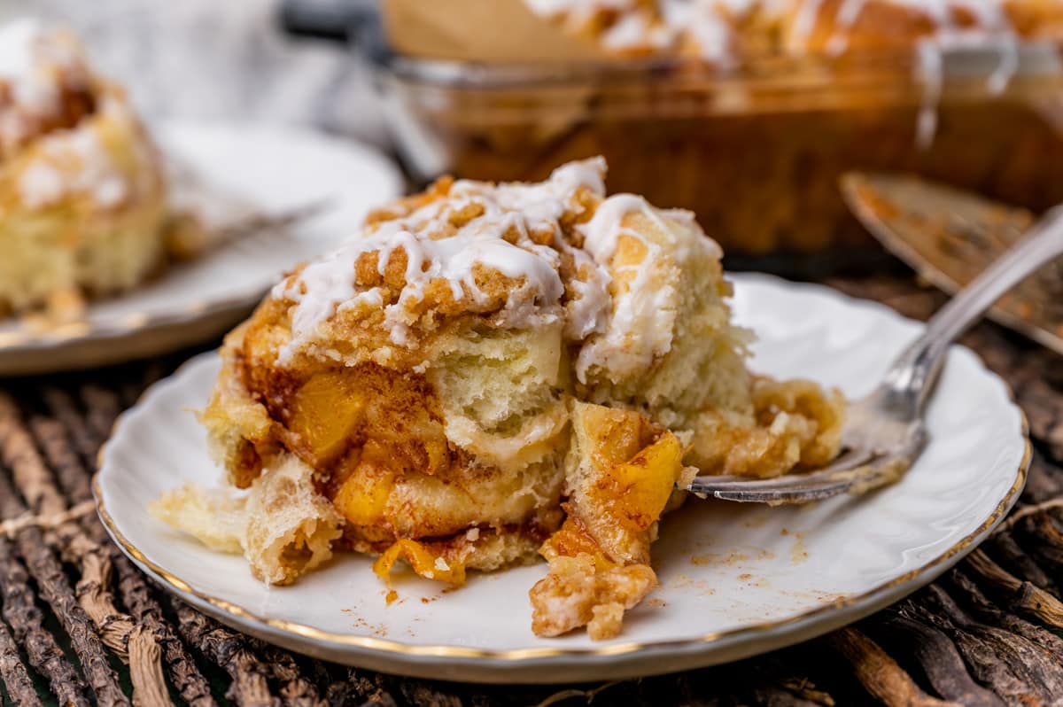 a cinnamon roll sitting on a plate with a fork