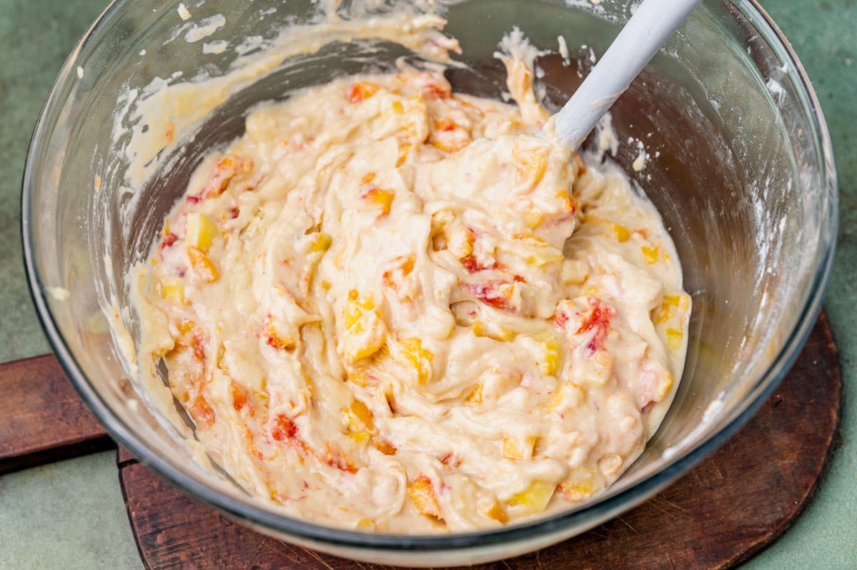 muffin batter with fresh peaches in a bowl