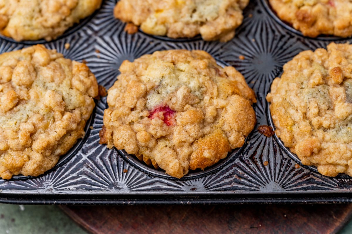 fresh peach crumble muffins in a muffin pan