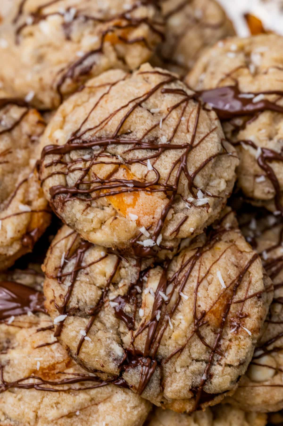 a stack of mango chocolate chip cookies with drizzled chocolate
