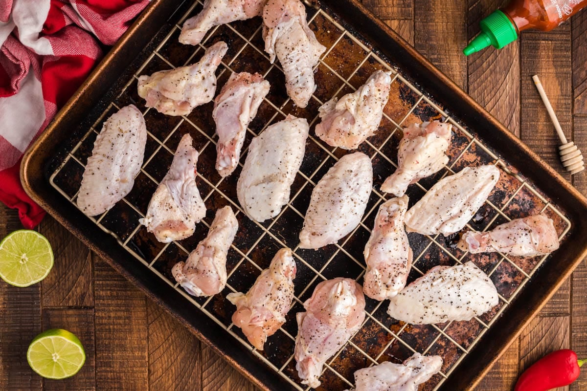 raw chicken wings sitting on a wire rack