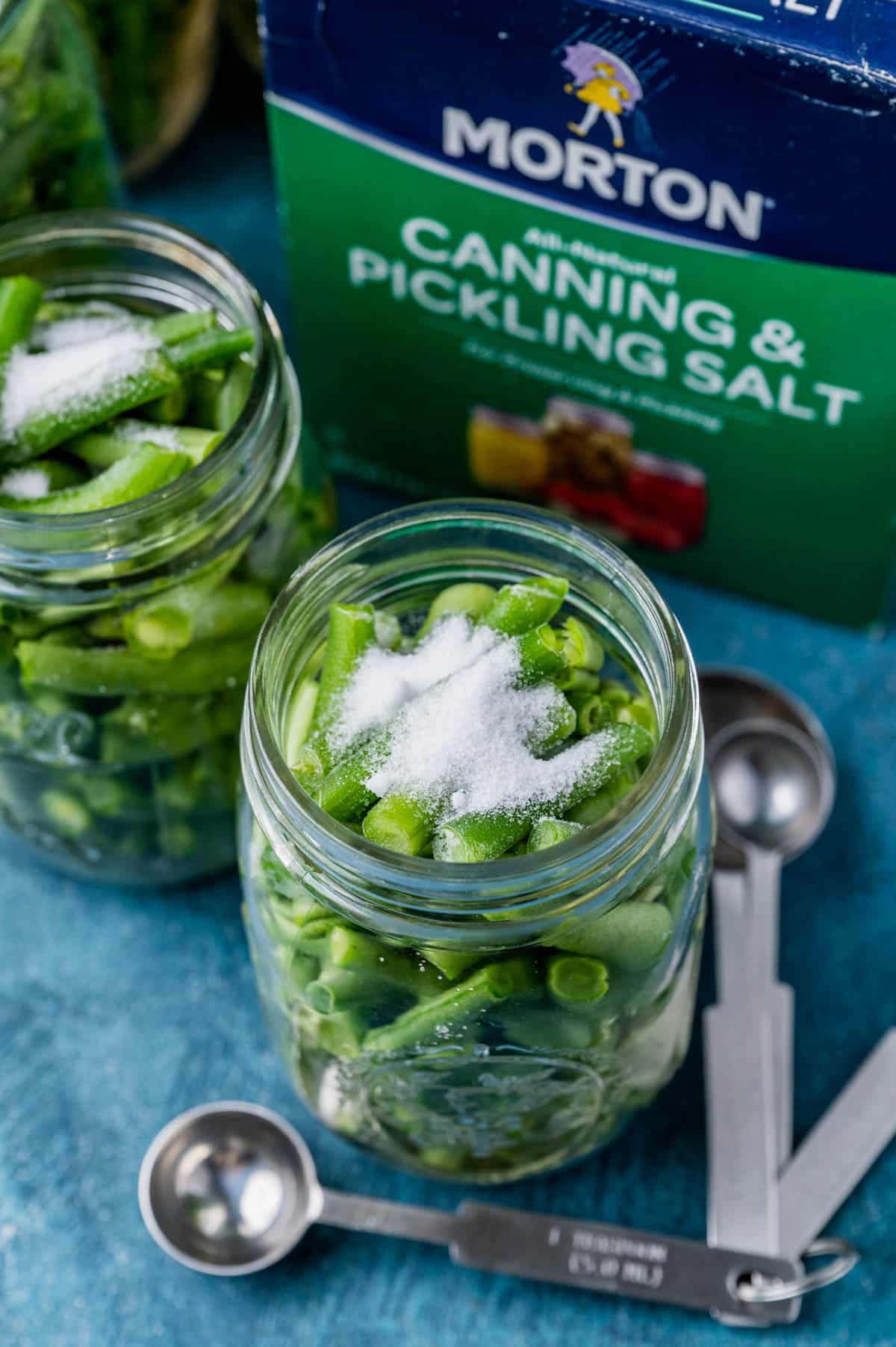 small mason jars with salt on a table