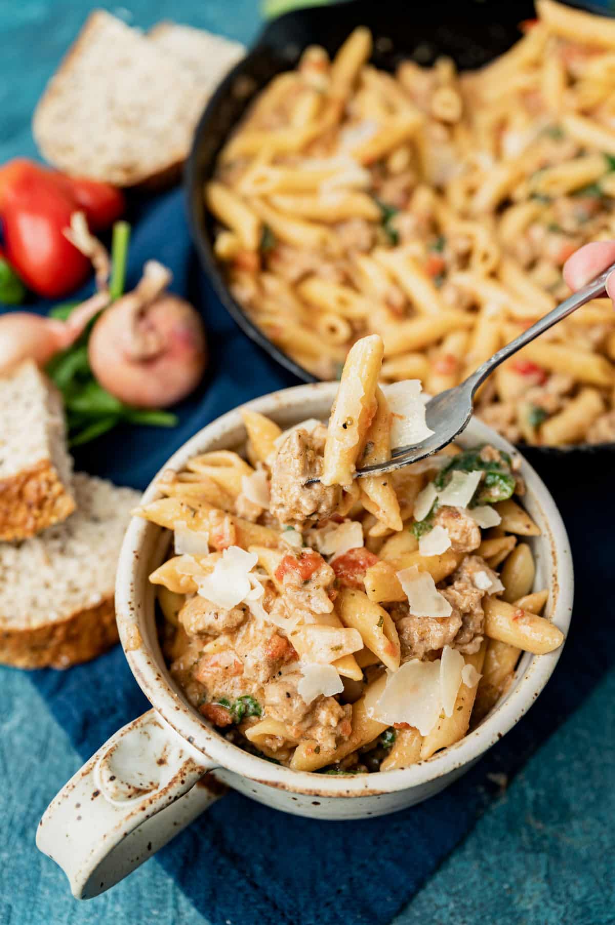 a bowl of italian sausage pasta with parmesan