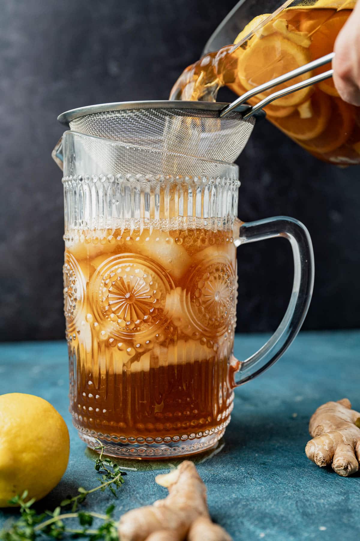 pouring iced tea into a pitcher
