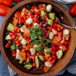 closeup of a bowl of cucumber tomato salad with pepperoni and mozzarella