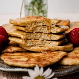 a stack of pancakes on a plate with syrup dripping down