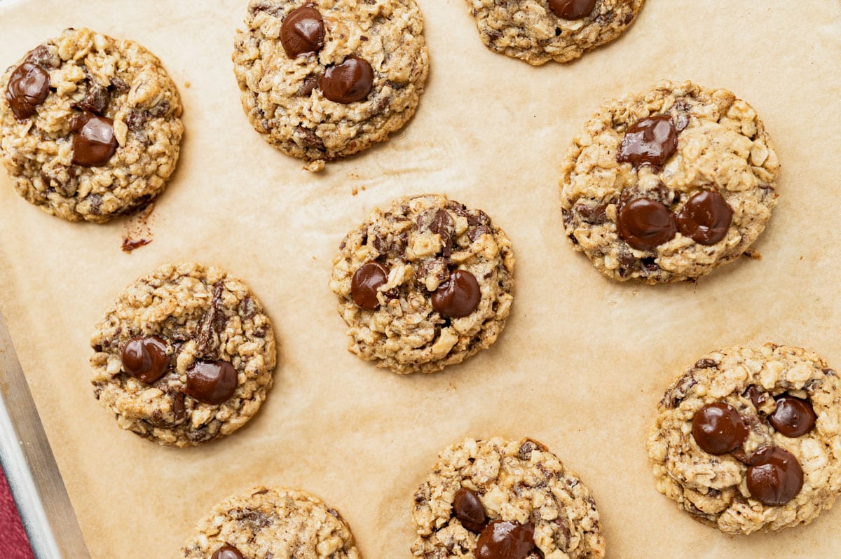 baked oatmeal cookies with chocolate chips on a pan