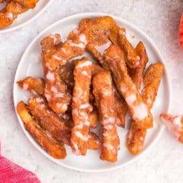 a plate of breaded apple fries with vanilla glaze