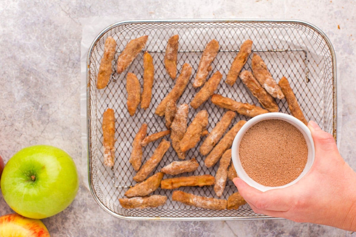 a cup with cinnamon and sugar to sprinkle over apple fries