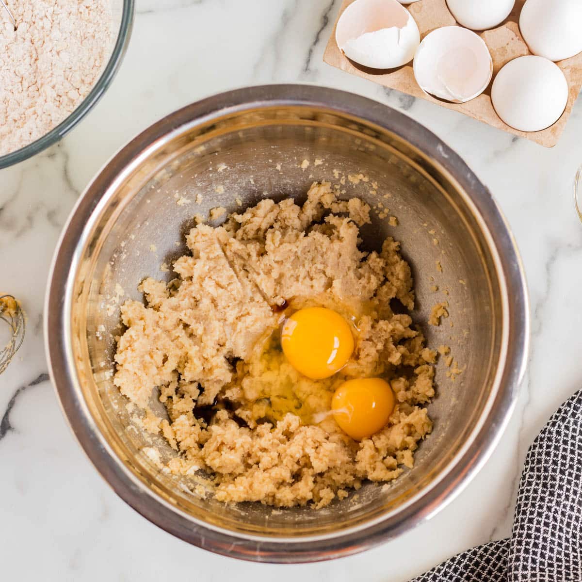 eggs in a bowl with creamed butter and sugar