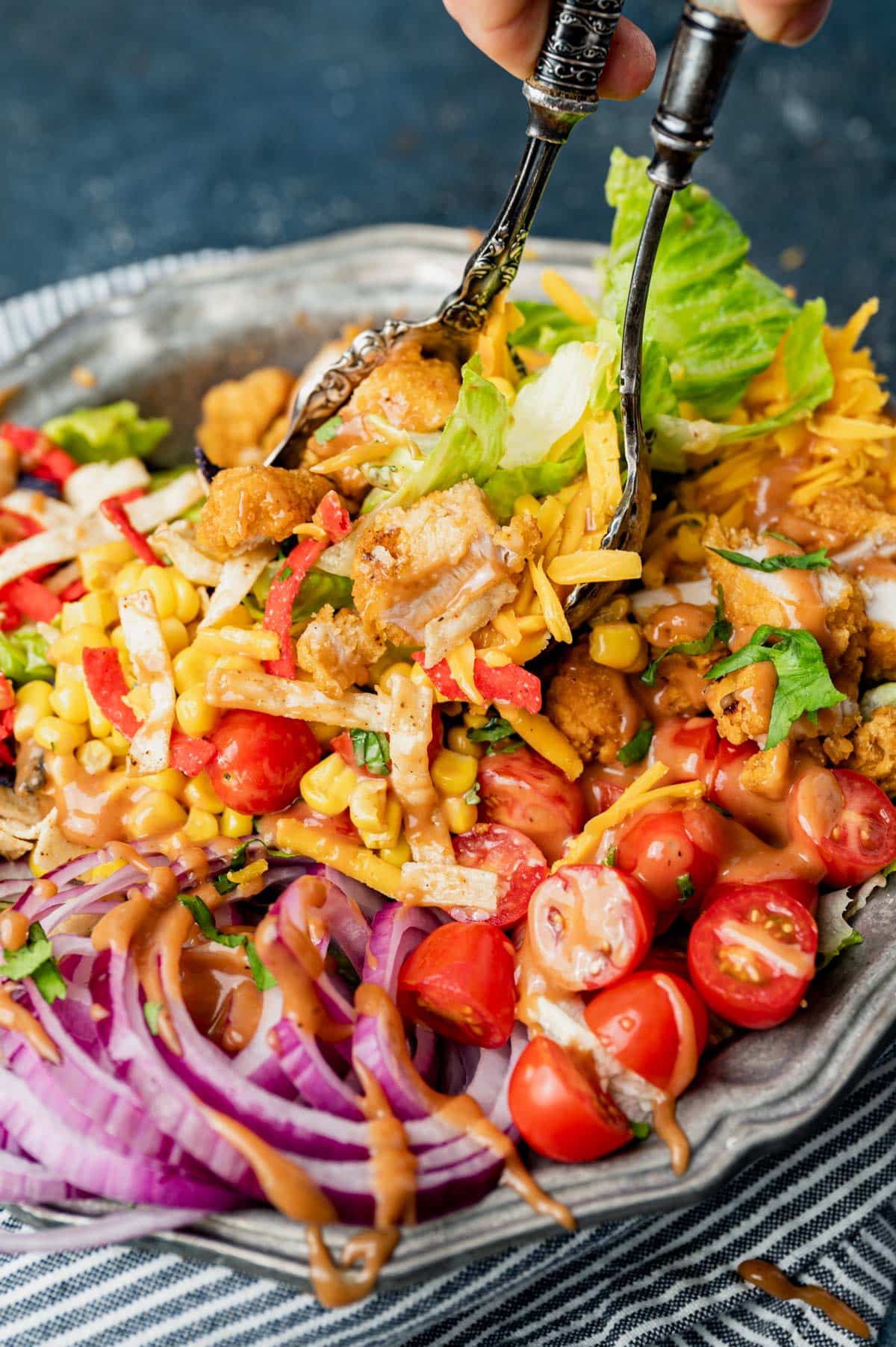 a large salad bowl with chicken, onion, corn, tomatoes