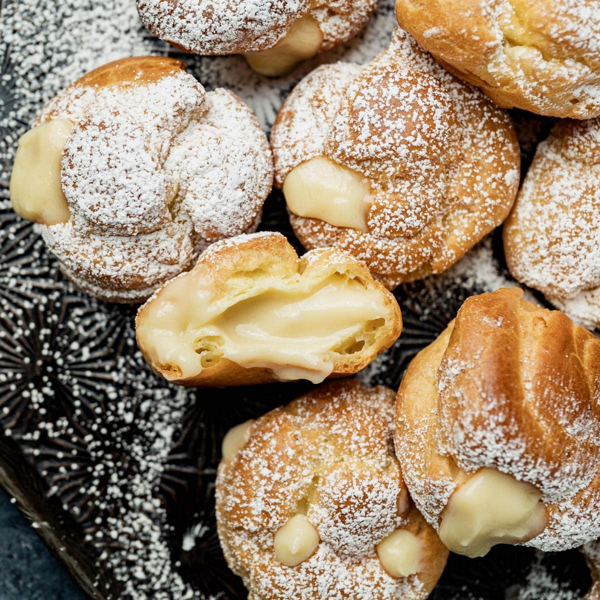 custard filled cream puffs on a pan