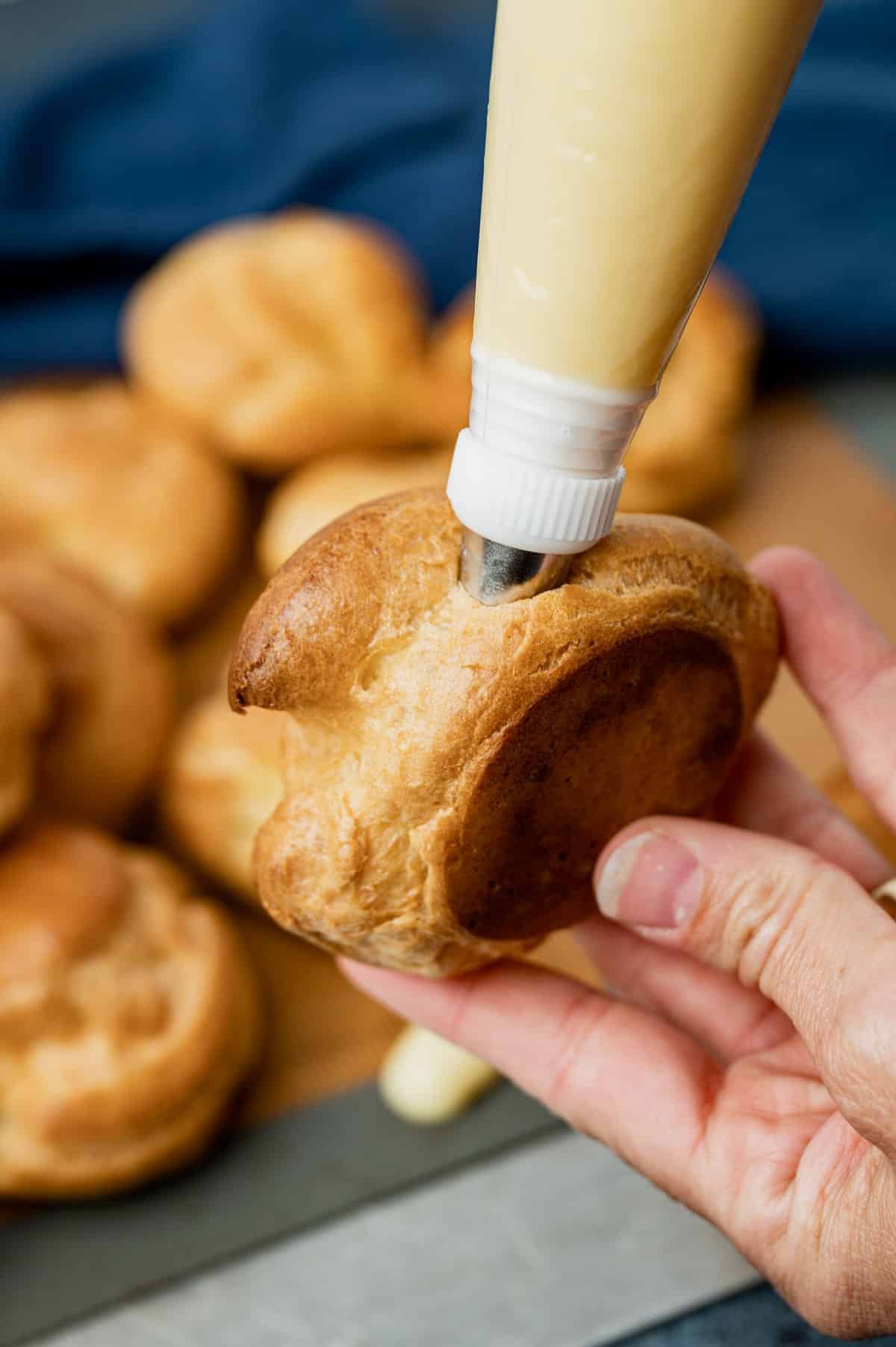 filling cream puffs using a piping bag