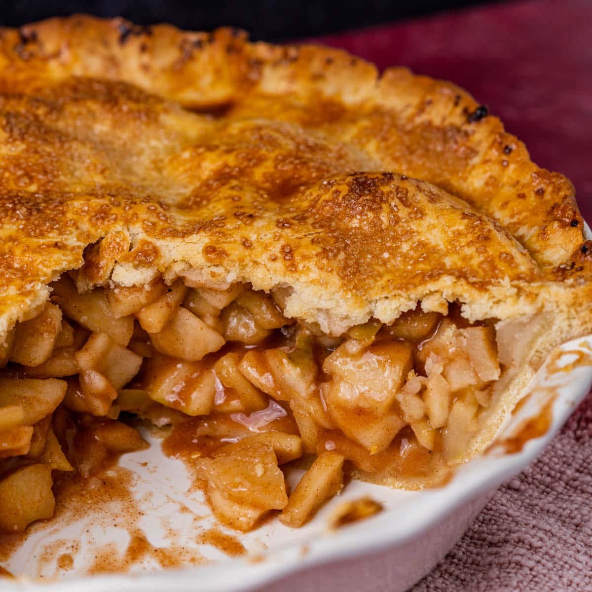an apple pie in a pie dish with a golden brown crust