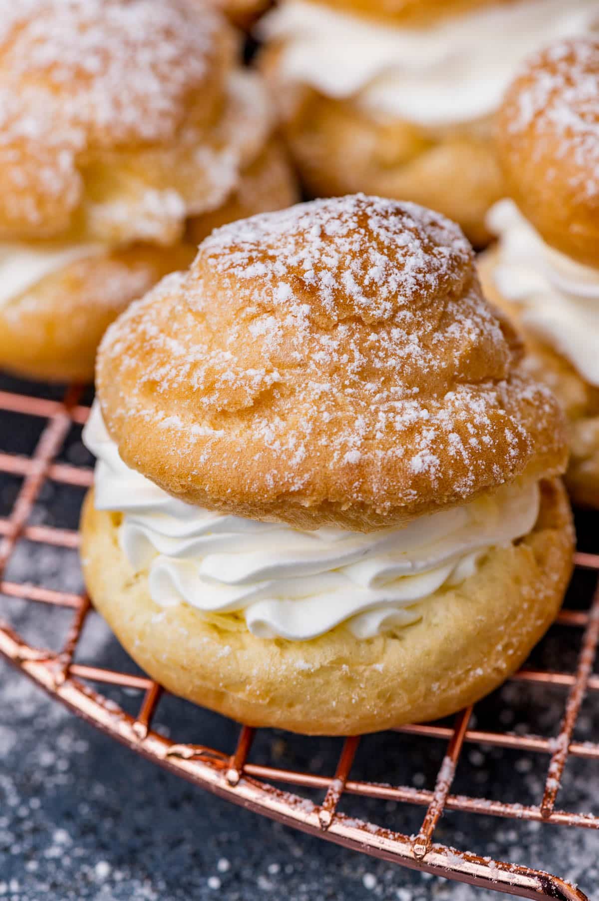 a cream puff filled with whipped cream on a wire rack