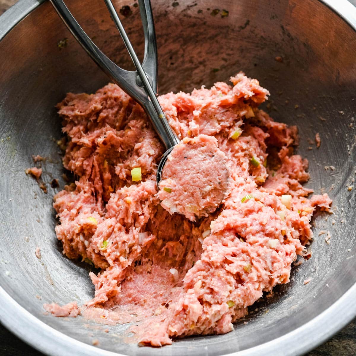 ground turkey with seasonings in a bowl with a scoop