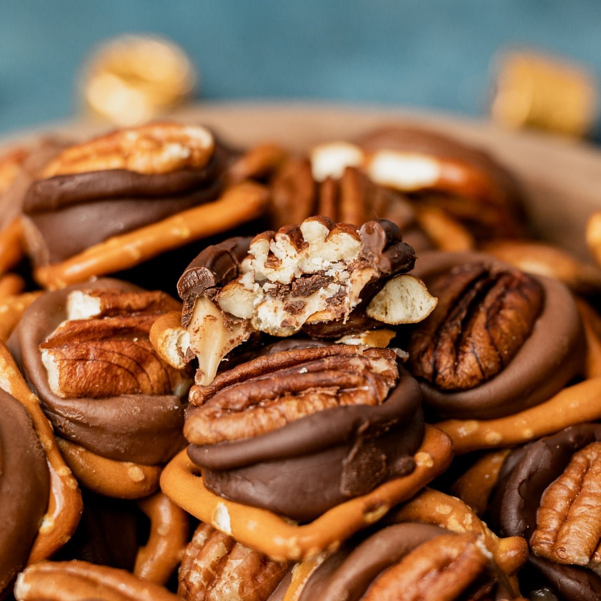 closeup of a bowl of pretzel rolo turtles, one with a bite out of it