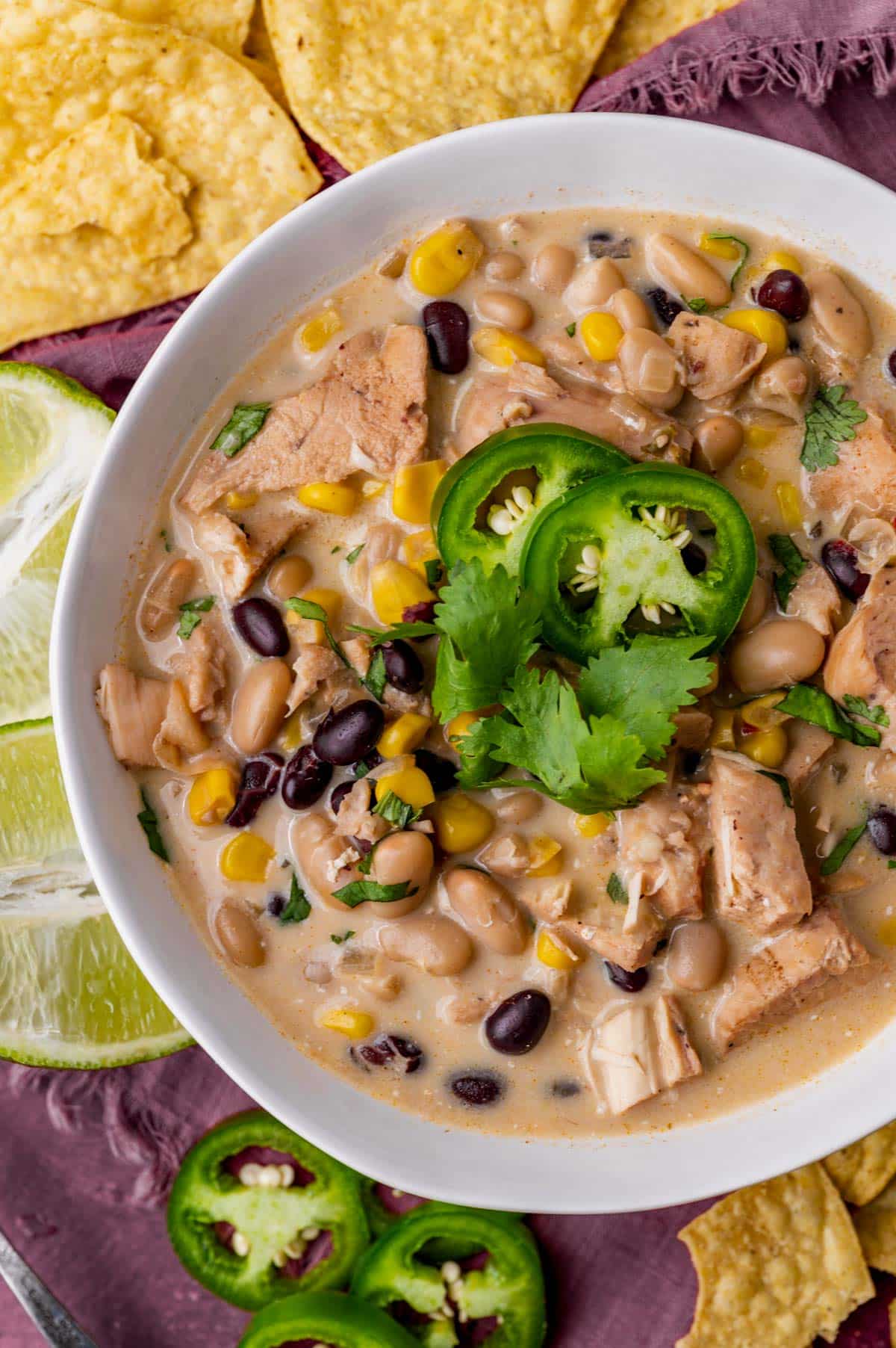 a bowl of white chicken chili with jalapenos and cilantro