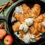 overhead view of a skillet of crescent roll apple dumplings with ice cream