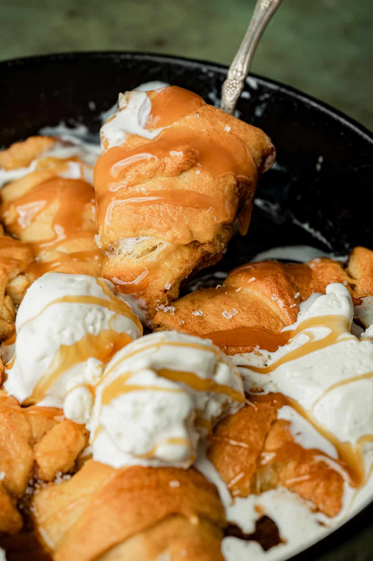 a spoonful of apple dumplings with caramel and ice cream