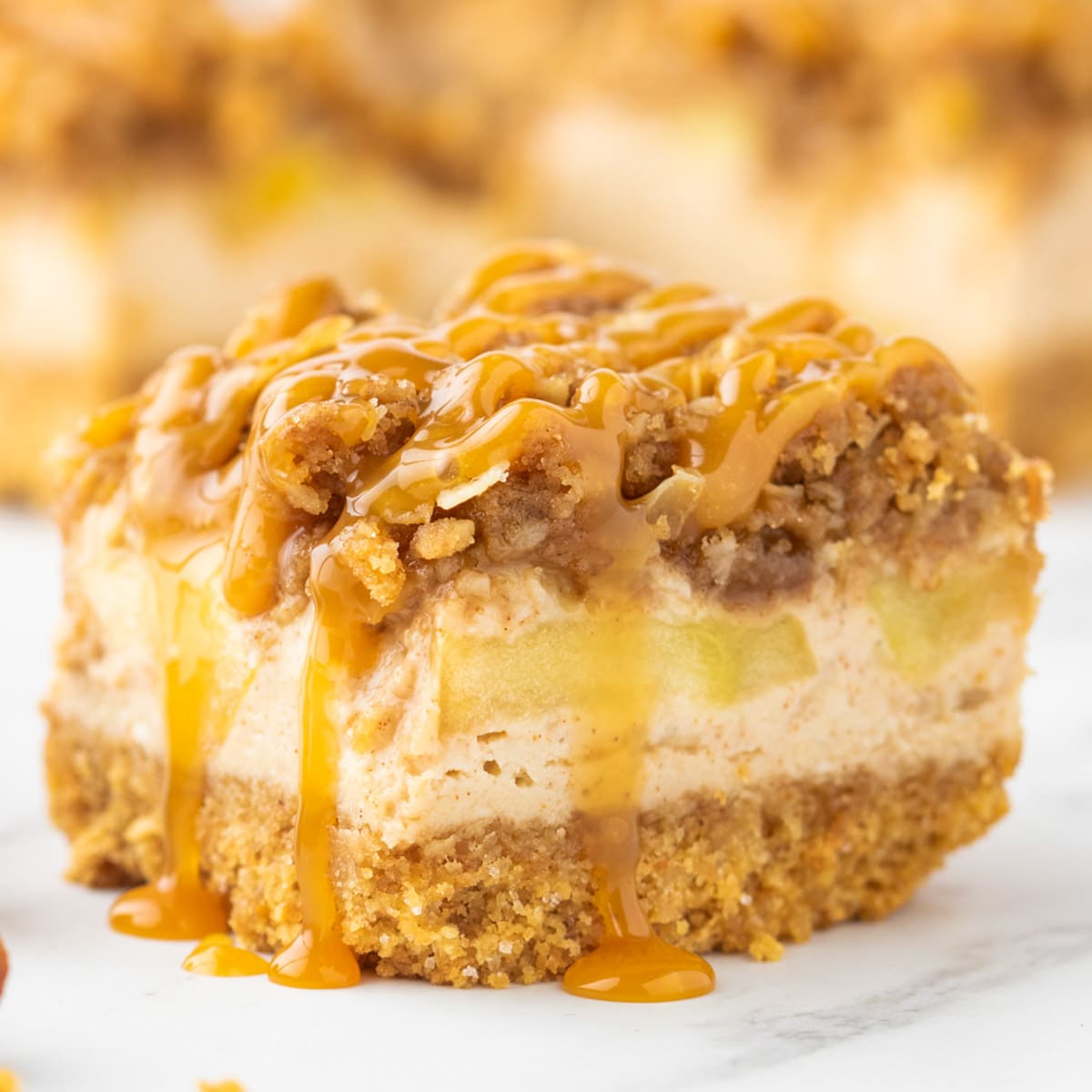 a cheesecake bar with streusel, caramel and apples