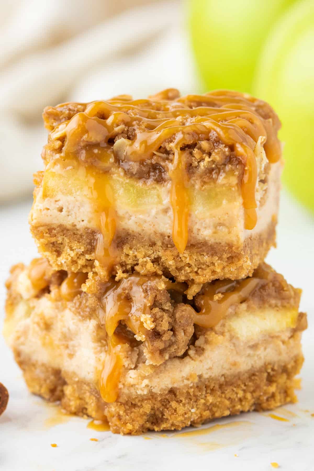 two caramel apple cheesecake bars stacked on each other