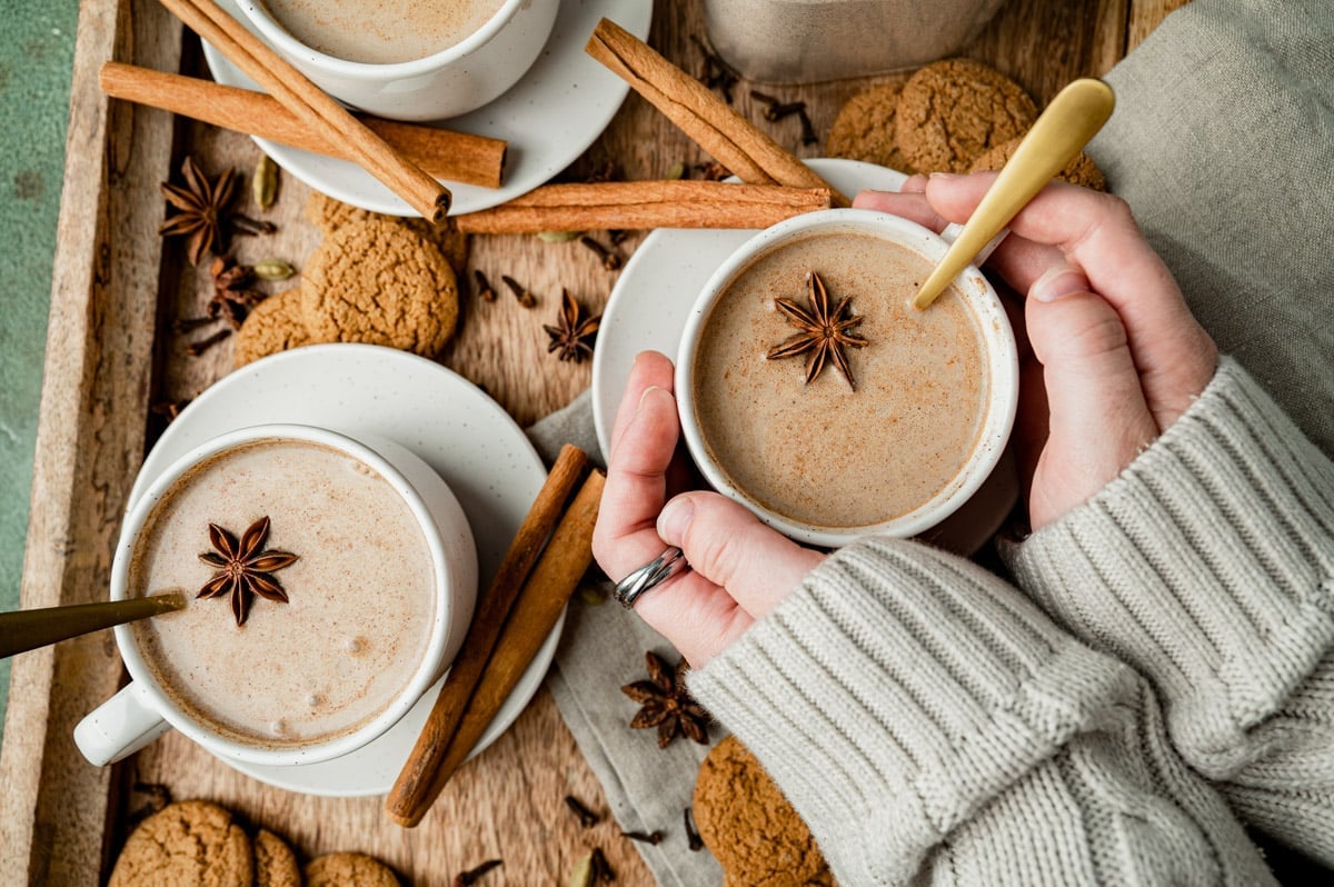 overhead view of hands holding a mug of chai latte