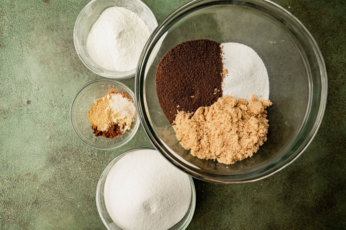 ingredients for chai latte mix in bowls on a table