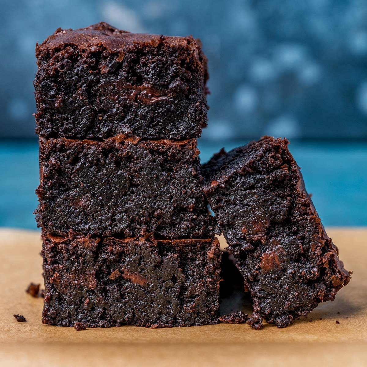 4 brownies stacked on parchment paper