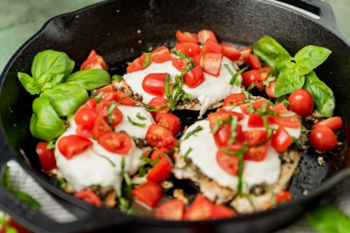 chicken with fresh mozzarella, tomatoes and basil in a skillet
