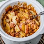 creamy scalloped potatoes and ham in a slow cooker with a spoon