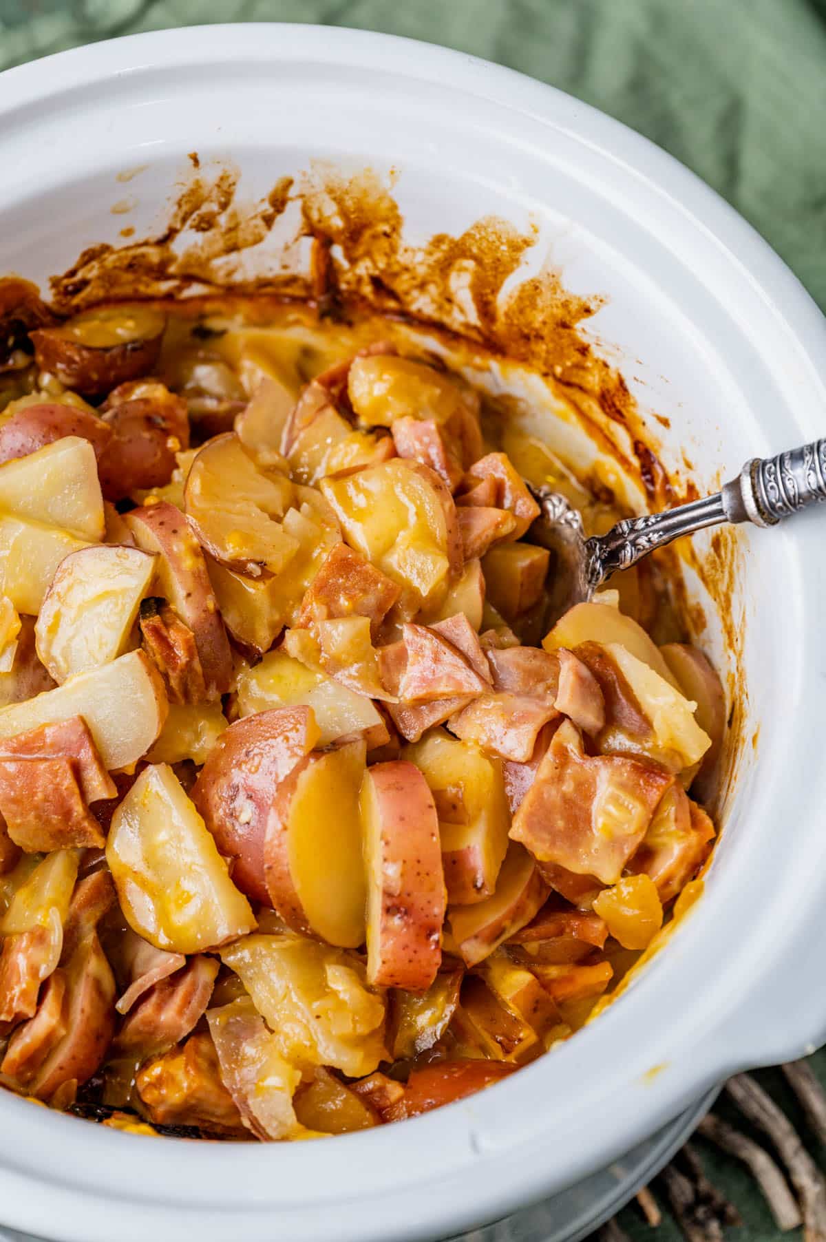 a slowcooker full of creamy scalloped red potatoes and ham