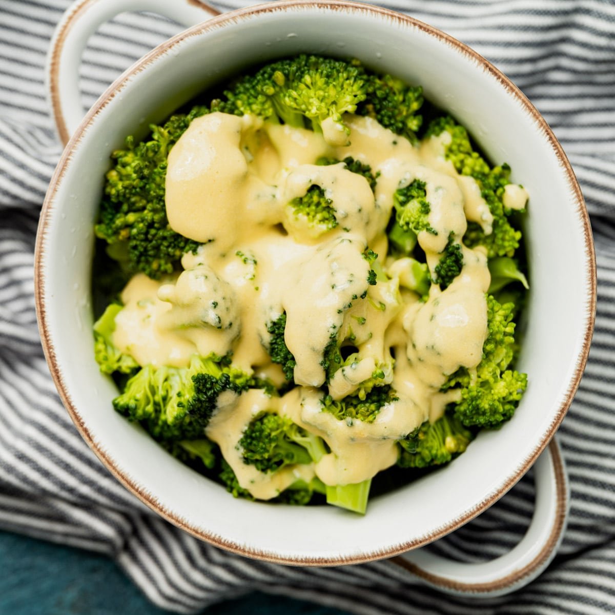 cheese sauce over broccoli in a bowl