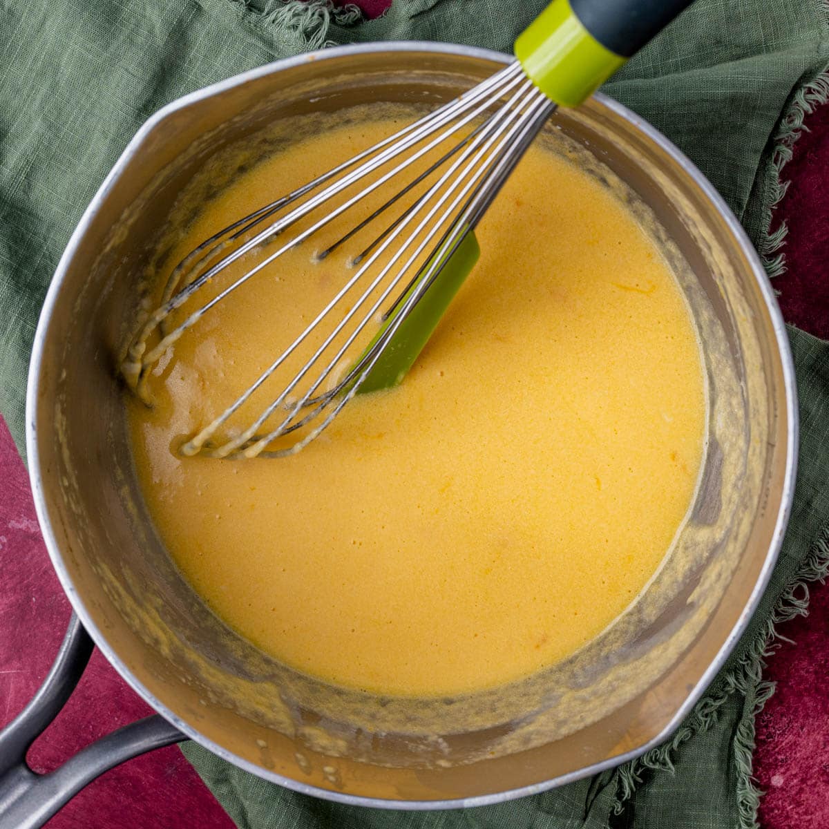 cheese sauce in a saucepan with a whisk