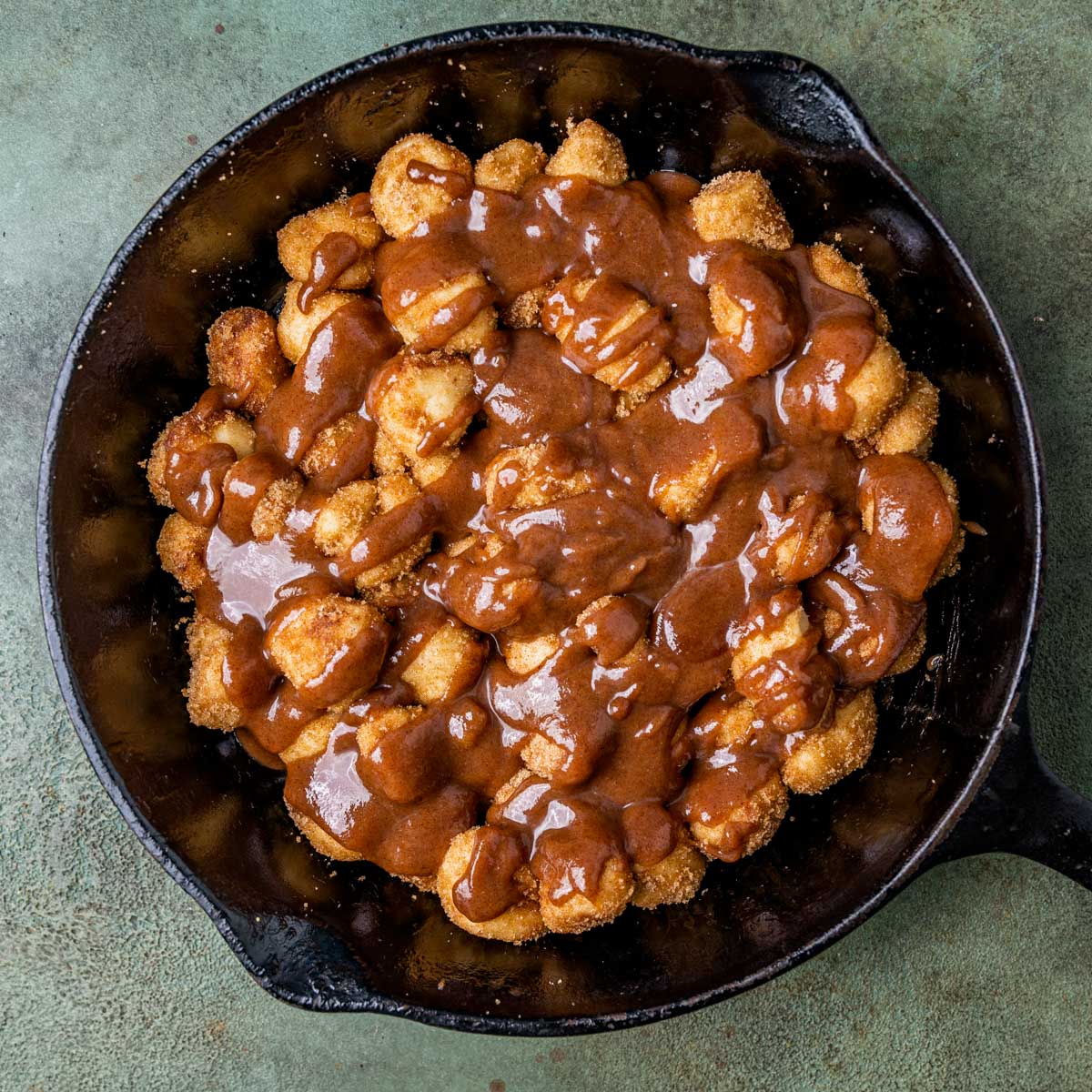 unbaked cinnamon roll bites with brown sugar glaze in a skillet