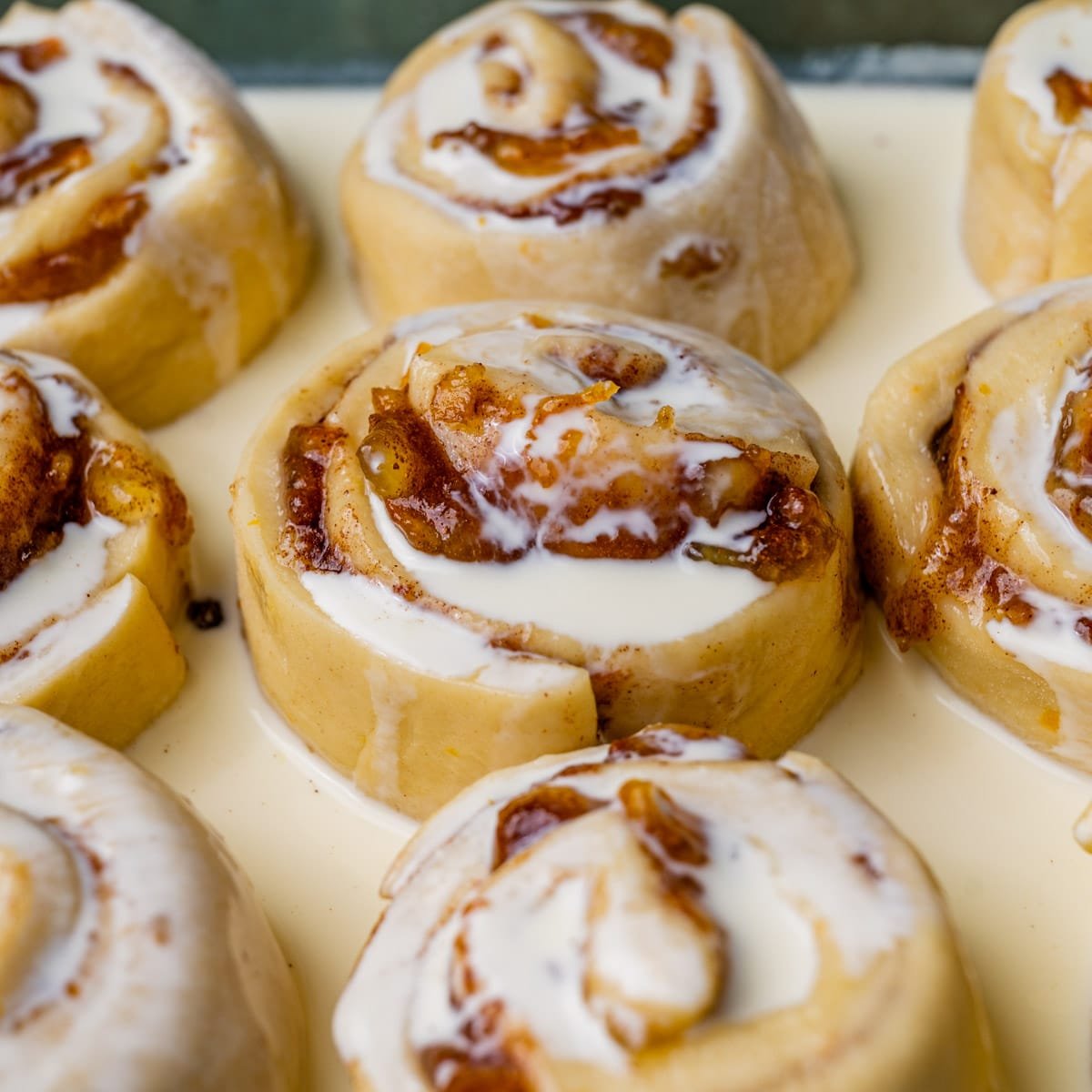 unbaked orange rolls with heavy cream over top