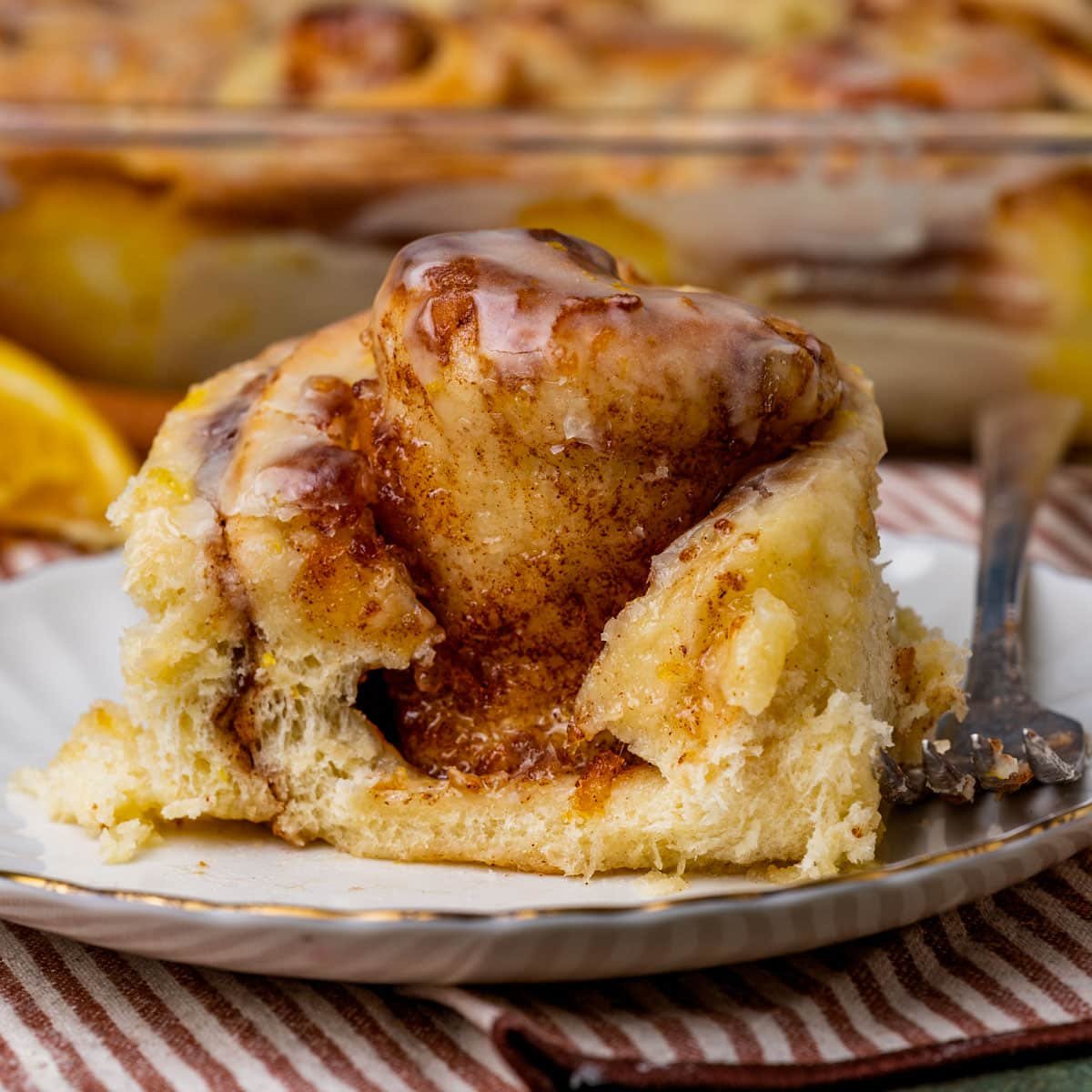 an orange roll on a plate with a bite out