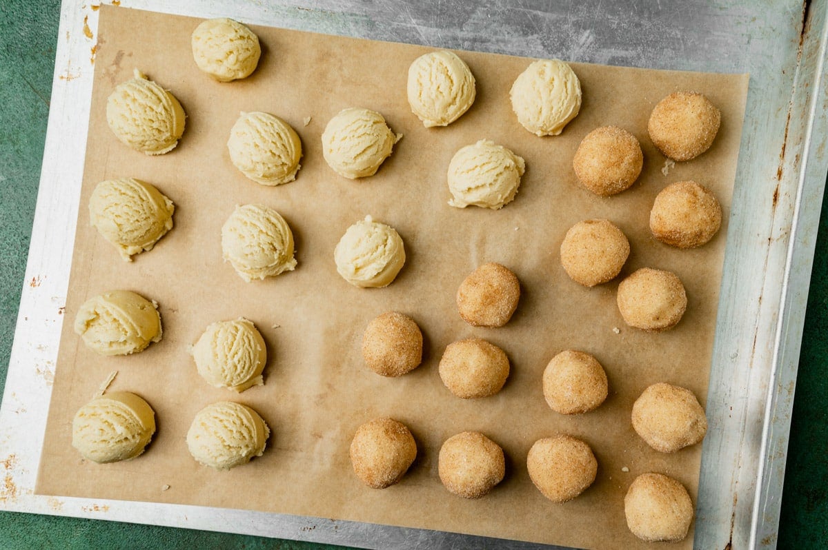 unbaked snickerdoodle cookie dough balls on a baking sheet