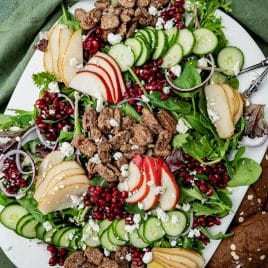 a large plate of christmas pear salad with feta cheese