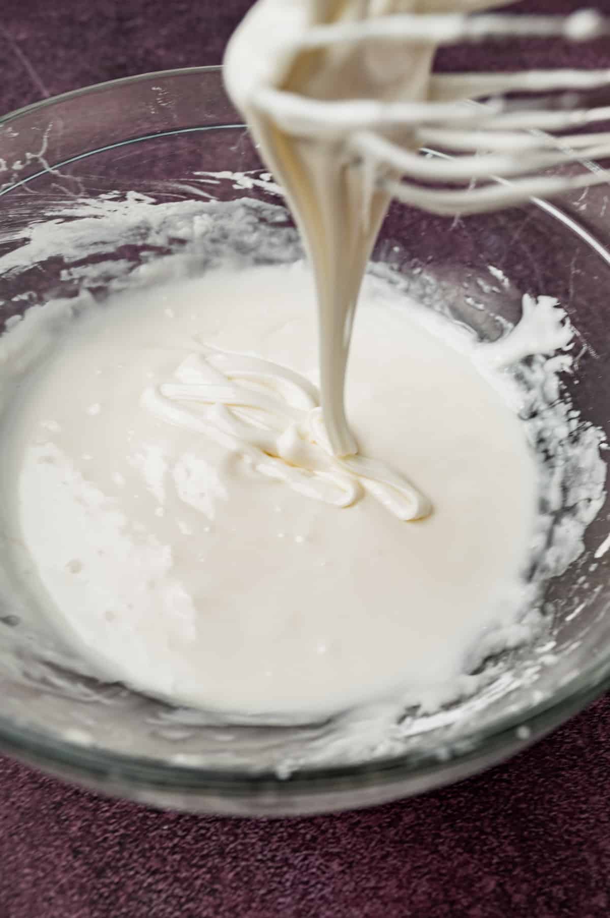 white sugar cookie icing drizzling in a glass bowl