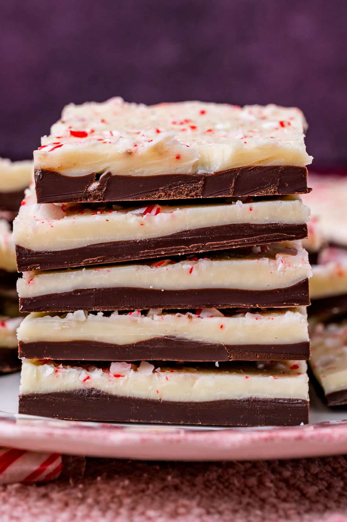 a stack of peppermint bark with crushed candy canes on a plate