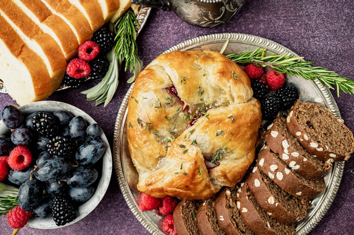 baked puff pastry on a plate with fresh berries and bread