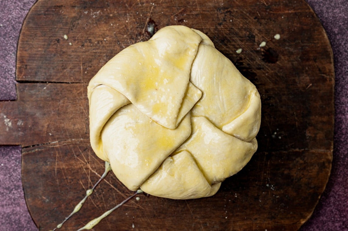 unbaked brie wrapped in puff pastry on a cutting board